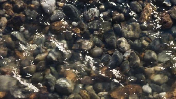 英国沃里克郡Arrow河清澈的河水，流过河床上不同颜色的石头和鹅卵石。