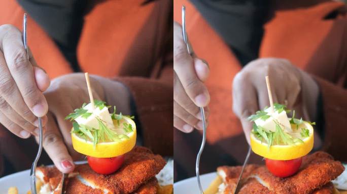 女人吃炸鸡排配薯片的垂直照片