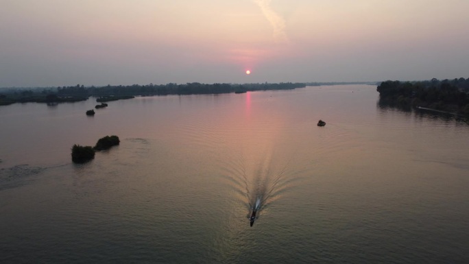 一名渔民在老挝南部壮阔的湄公河上，赶在日落前回家。