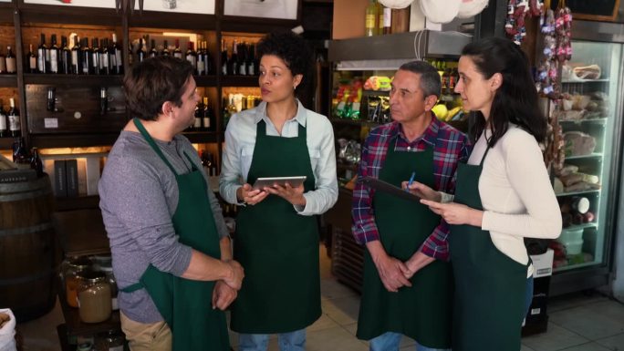 一家熟食店的女经理在开始服务前与她的团队交谈并给出指示