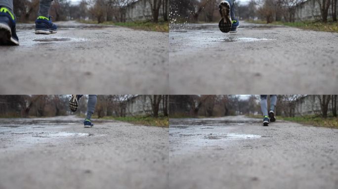年轻运动员沿着乡间小路慢跑时踩进水坑的双腿。运动型男子在雨中沿着乡间小路奔跑的双脚。运动服户外训练的