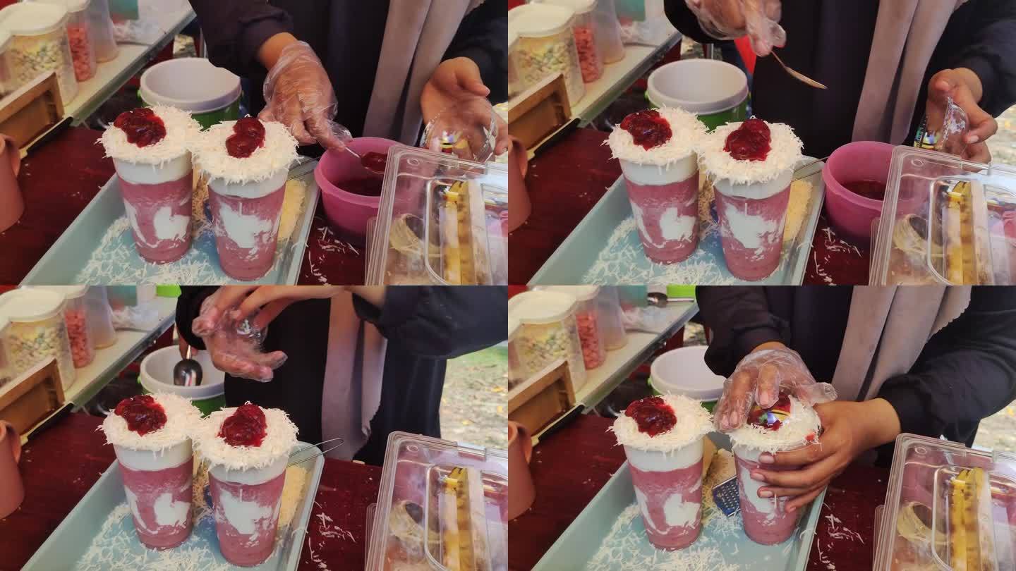 过程视频是呈现新鲜的冰沙饮料与草莓和奶油口味和磨碎的奶酪浇头