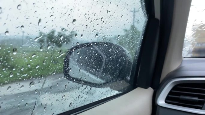 从侧窗看大雨中行驶的汽车