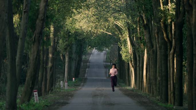 女子在幽静的林间小道慢跑锻炼身体