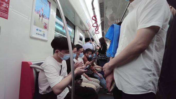 坐地铁玩手机的年轻人