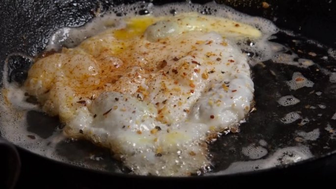 特写:在热铁锅里煎鸡蛋，在黄油里滋滋作响