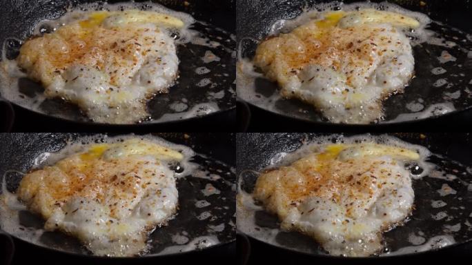 特写:在热铁锅里煎鸡蛋，在黄油里滋滋作响