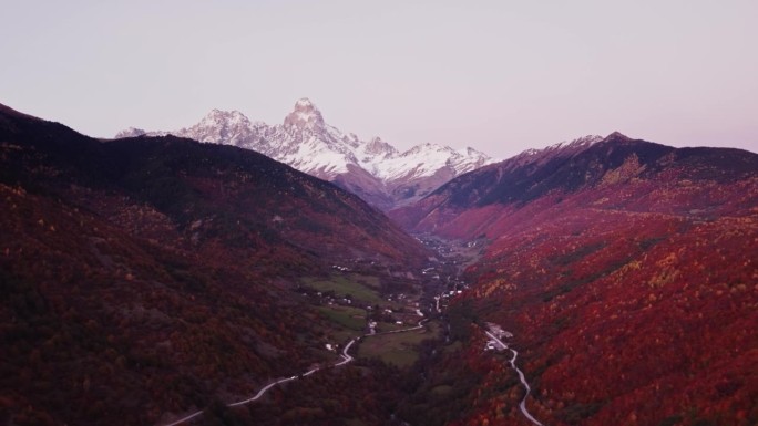 迷人的山村坐落在雪峰的山坡上，周围是峡谷和悬崖