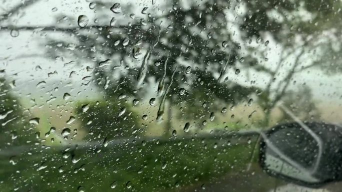 从侧窗看大雨中行驶的汽车