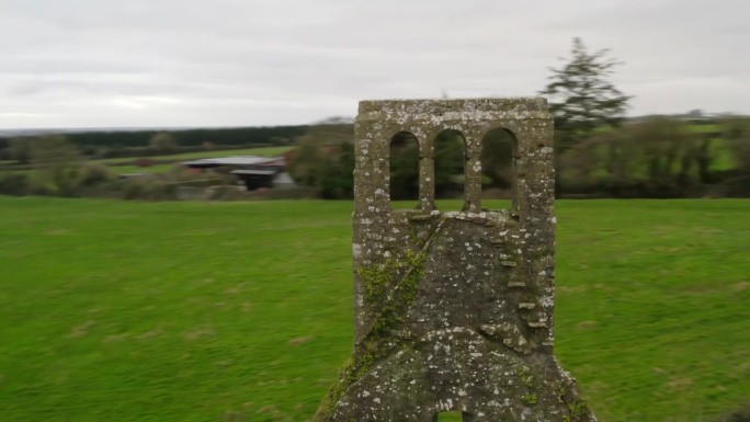 爱尔兰乡村残教堂薄砖钟楼周围的快速轨道视差