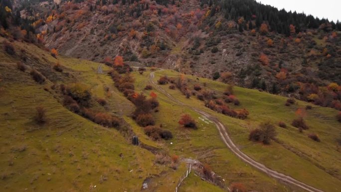 近景航拍的古教堂建在山上，附近的高山覆盖着秋天的树木