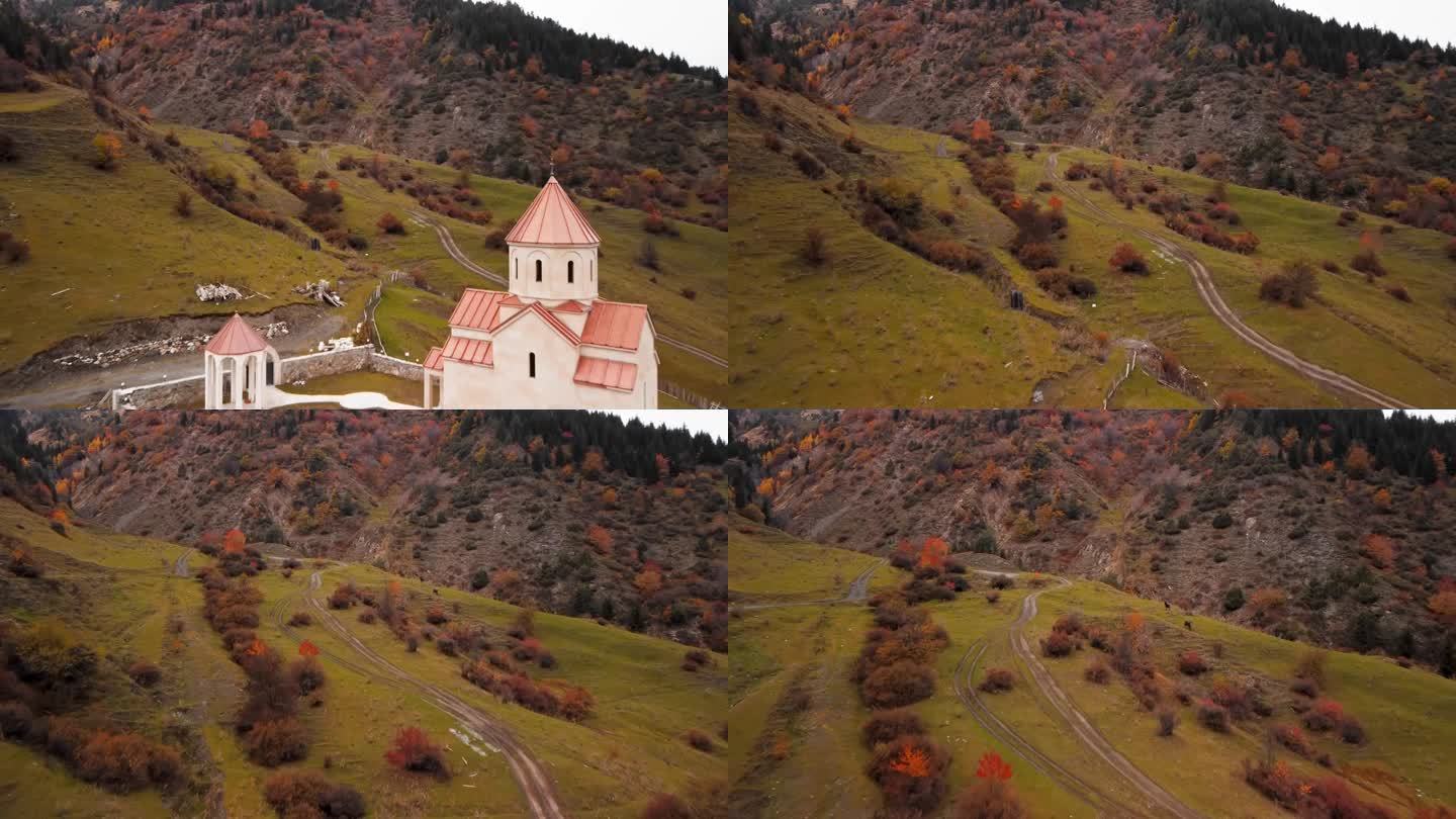 近景航拍的古教堂建在山上，附近的高山覆盖着秋天的树木