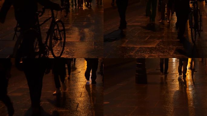 特写:在一个下雨的晚上，城市人的脚走在闪闪发光的湿人行道上