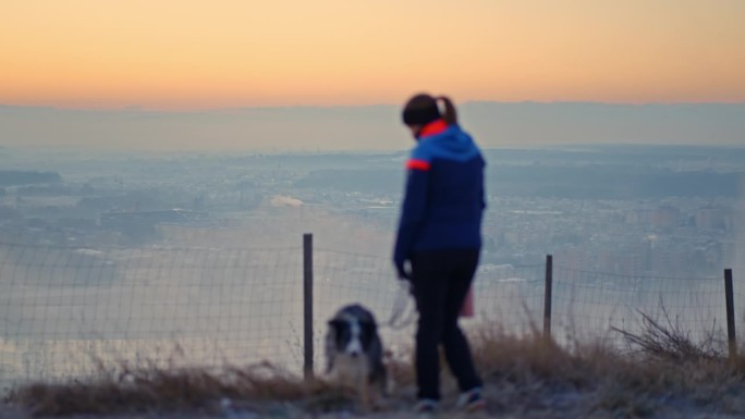 SLO MO模糊女人和狗在山上俯瞰美丽的日出景观