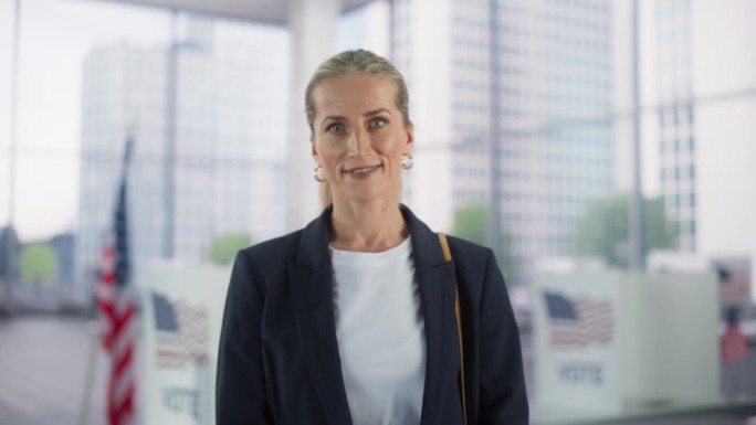 一位美丽的白人女商人在美国国旗的大城市办公室摆姿势的肖像。成年女经理微笑着看着镜头。工作中成功的商业