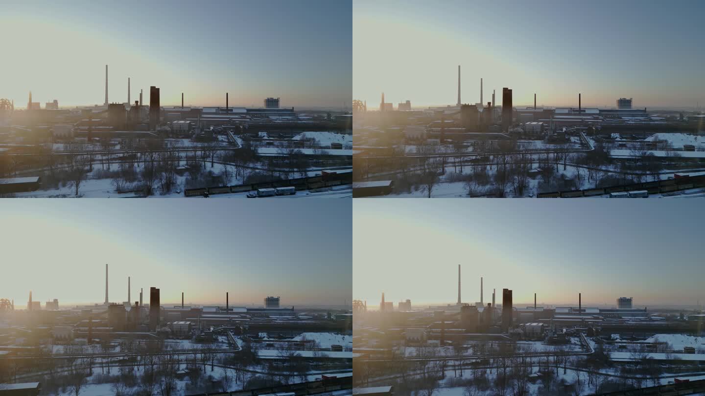 广阔的白雪覆盖的工业园区沐浴在日出或日落的柔和光芒中。