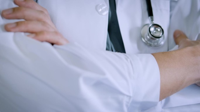 医生带着听诊器。医生的白大褂自信地站在那里，双臂交叉。值得信赖的医生和健康保险的概念