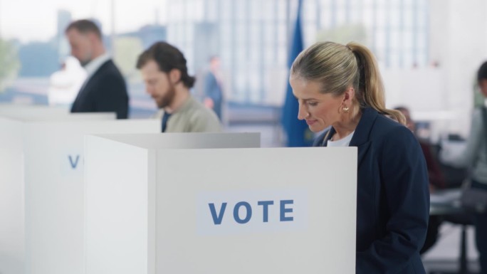 图为欧盟国家选举当天，一位美丽的成年女性在投票站填写选票。在一个欧盟国家，不同的男性和女性投票选举官