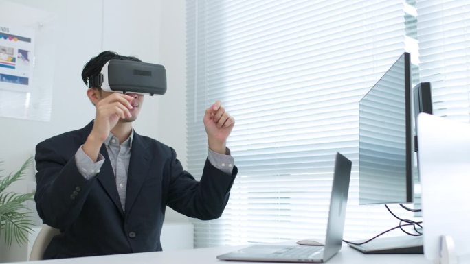 亚洲商人在现代办公室中使用虚拟现实视觉耳机与数据图形模拟来规划工作