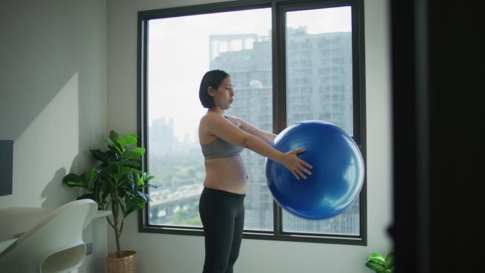 孕妇在公寓里用瑜伽球练瑜伽