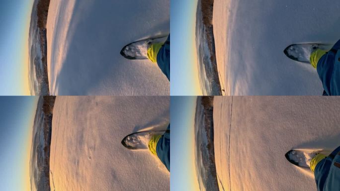 垂直视角:在一个美丽的阳光明媚的早晨，滑雪板运动员在雪地上滑行