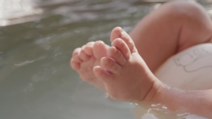 在明亮之家的浴缸里，婴儿漂浮在水面上的SLO MO锁定低剖面镜头