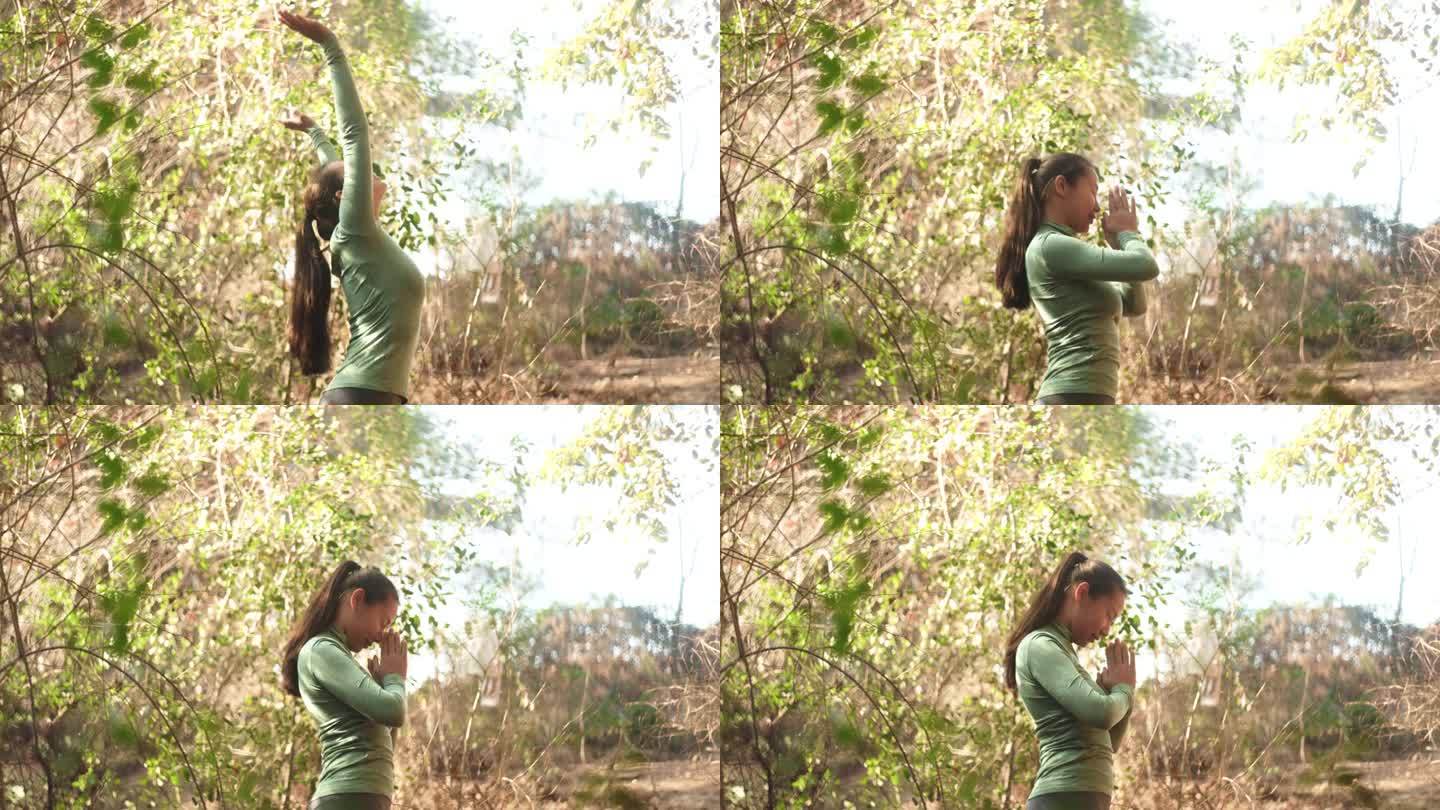 向太阳致敬的瑜伽:年轻女子在森林砍伐中的练习