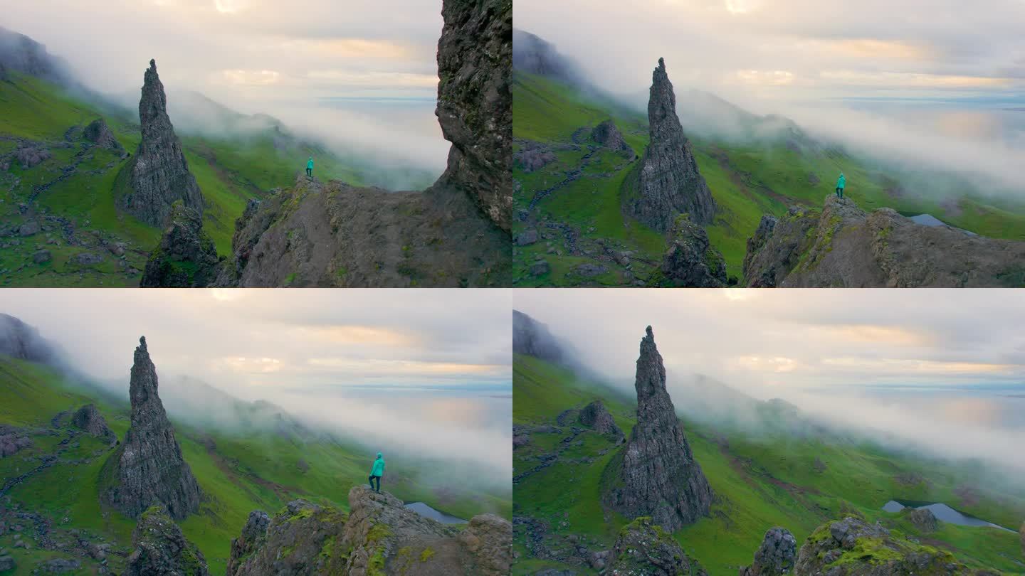 空中女人爬到观景台，在那里她欣赏着雾气蒙蒙的大教堂岩