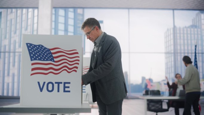 受人尊敬的成年男子在填写选票。美国人民在美国的选举日。不同的人在投票站为他们喜欢的候选人投票