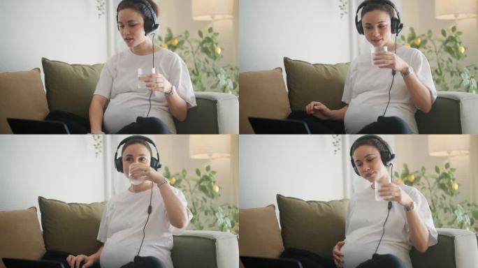 孕妇喝水，用电脑了解假期在家工作的细节。