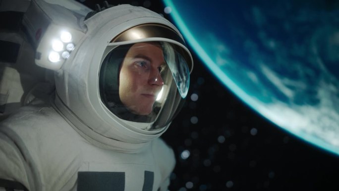 男性太空探险家在太空旅行，发现我们宇宙的深处。一个戴着头盔的年轻男子的特写镜头，从太空中看到的地球景