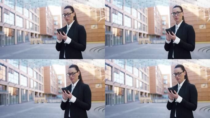 白人女商人在大城市街道上使用智能手机的肖像。自信的管理者在工作休息时间上网、发信息、上网