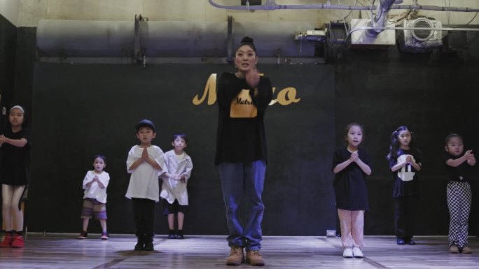 日本的孩子们在舞蹈室里和他们的老师跳舞