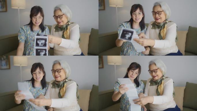 一位怀孕的母亲和她的妈妈看着超声波上未来宝宝的照片
