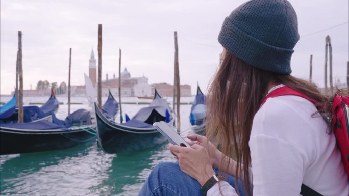 在欧洲的意大利威尼斯，年轻的旅行者用智能手机上的应用程序导航。