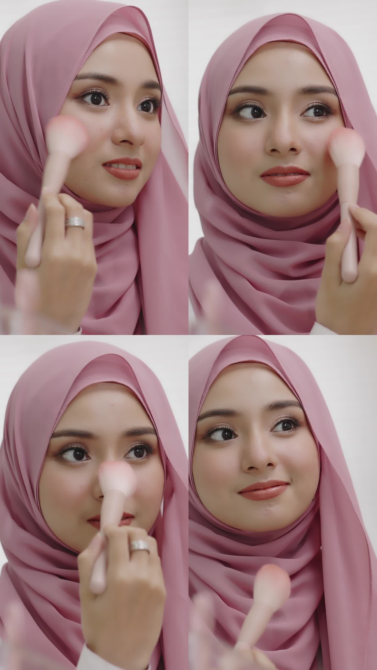 年轻的亚洲美丽的穆斯林妇女戴着头巾照镜子，每天在家里用脸颊刷化妆。漂亮的女孩在脸上刷妆。