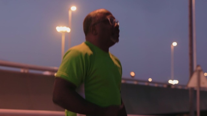 在黄昏的宁静中，这位五十多岁的绅士在原地慢跑，为跑步热身。