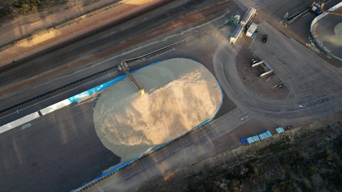 澳大利亚西部，一辆谷物卡车正通过管道将谷物卸入一个巨大的筒仓。