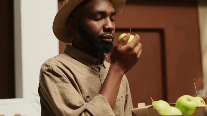 非裔美国人在超市闻着当地出产的苹果
