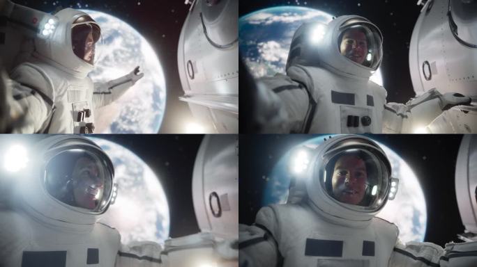 屏幕替换概念，一个年轻的宇航员漂浮在零重力的太空中，以地球为背景进行视频通话。工程师在开放空间使用智