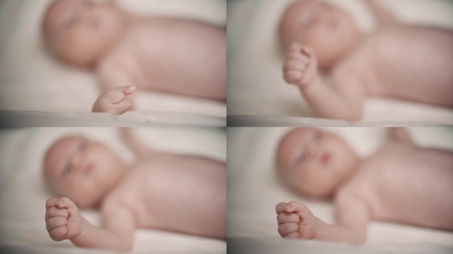 宝宝躺在床上的高角度镜头，聚焦在家里的拳头