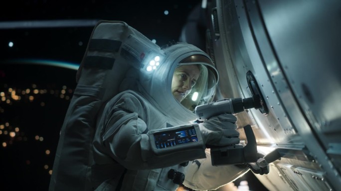 女太空技术人员正在用自动螺旋枪修理国际空间站上的面板。无畏的宇航员在外太空工作，背景是美丽的蓝色星球