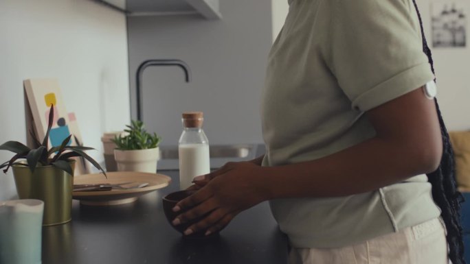 患有糖尿病的非裔美国妇女把牛奶倒进碗里