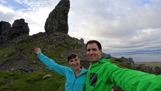 自拍照:一对微笑的年轻夫妇在“Storr老人”的岩石中旋转