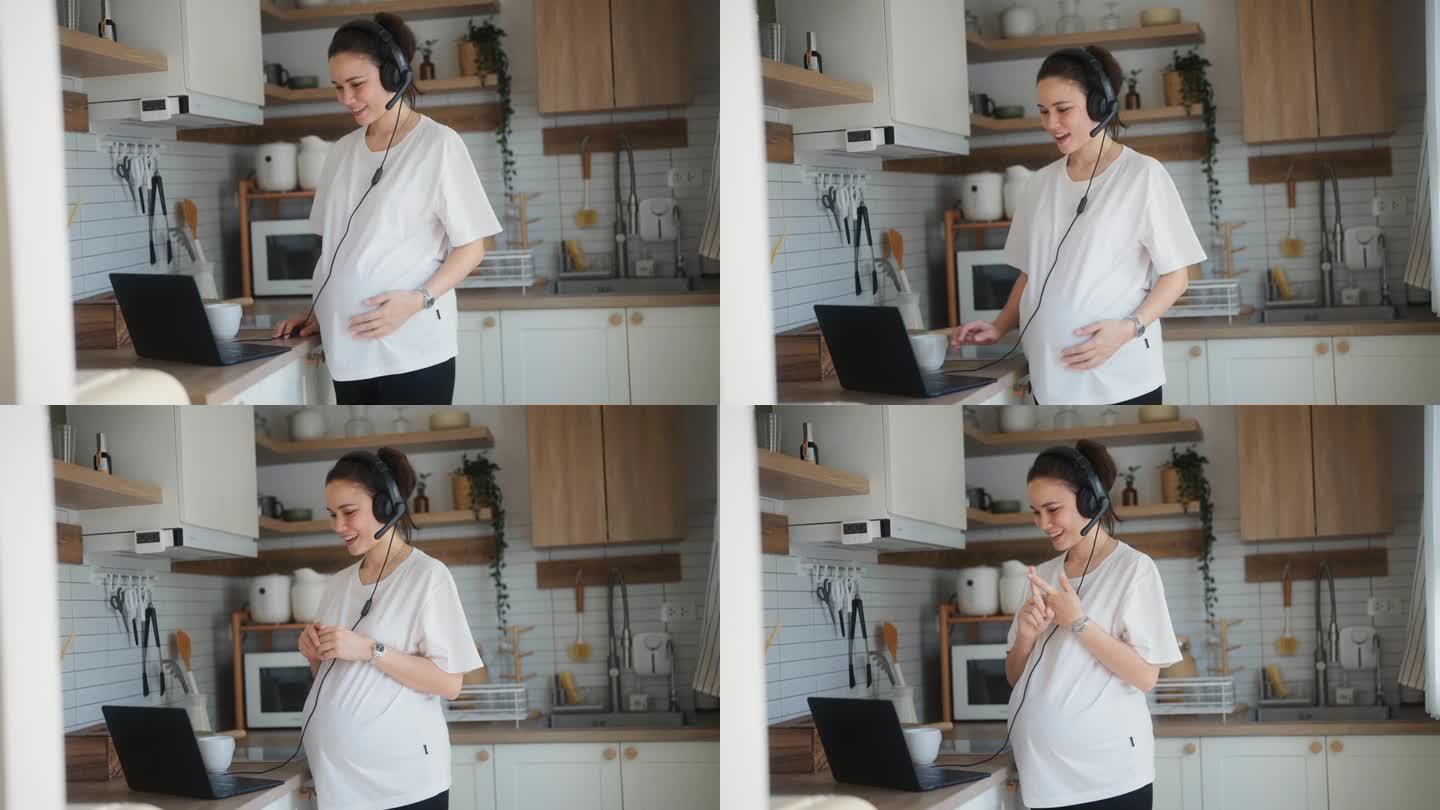 聪明的孕妇在现代化的厨房里利用电脑与同事见面