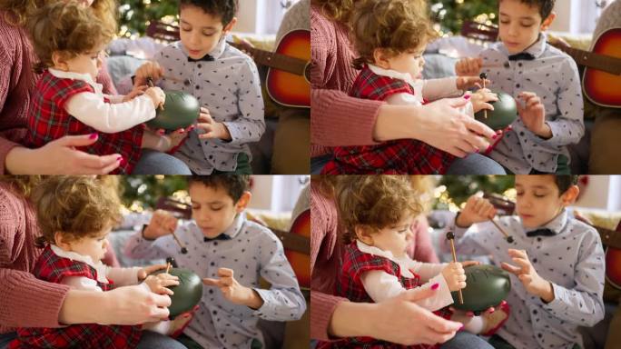 哥哥和姐姐在圣诞节和妈妈一起玩舌鼓