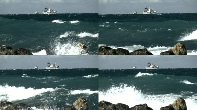 暴风雨的海浪冲击着海岸，一艘渔船在海上(慢动作)