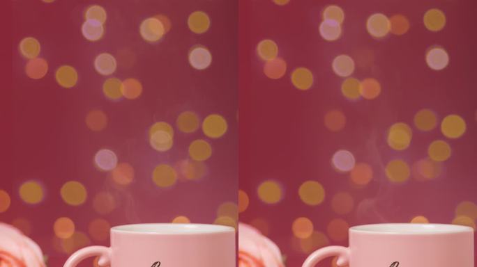 粉红色咖啡杯里用烟熏的热饮，旁边写着“爱”字，木桌上并排摆放着玫瑰和两颗小心，背景上散焦的散景光。浪