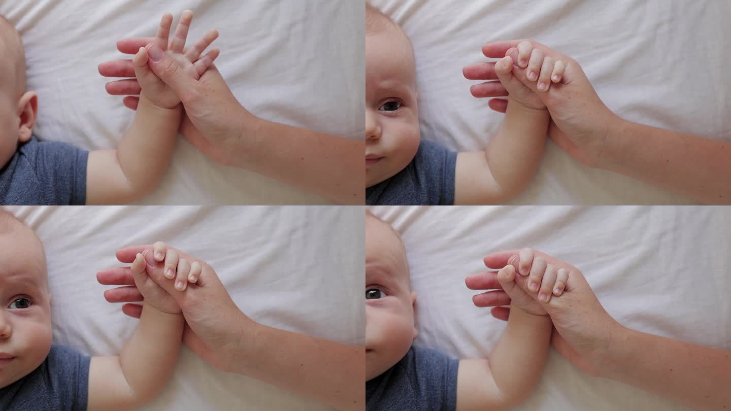 新生儿紧紧抓住母亲的手和手指的特写镜头。童年、新生活和为人父母的概念