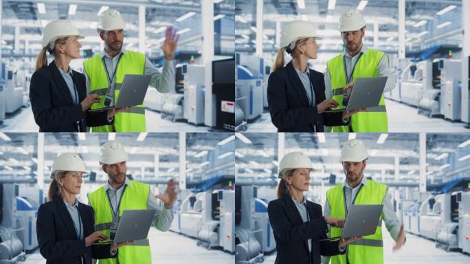 两个戴着安全帽的专业重工业工程师在笔记本电脑上讨论工厂工作。在电子生产厂工作的白人女性专家和男性技术